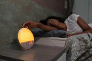 Mulher está deitada na cama e ao lado dela tem um despertador para ilustrar o circo circadiano.