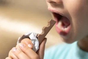 Criança leva chocolate à boca e tem sintomas de fagofobia.